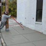 Man pouring concrete on a sidewalk